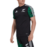 A person wearing a black and green Maori All Blacks Performance Polo by adidas, showcasing the "New Zealand All Blacks" logo and design elements on the sleeves, equipped with moisture-wicking AEROREADY technology for enhanced comfort.