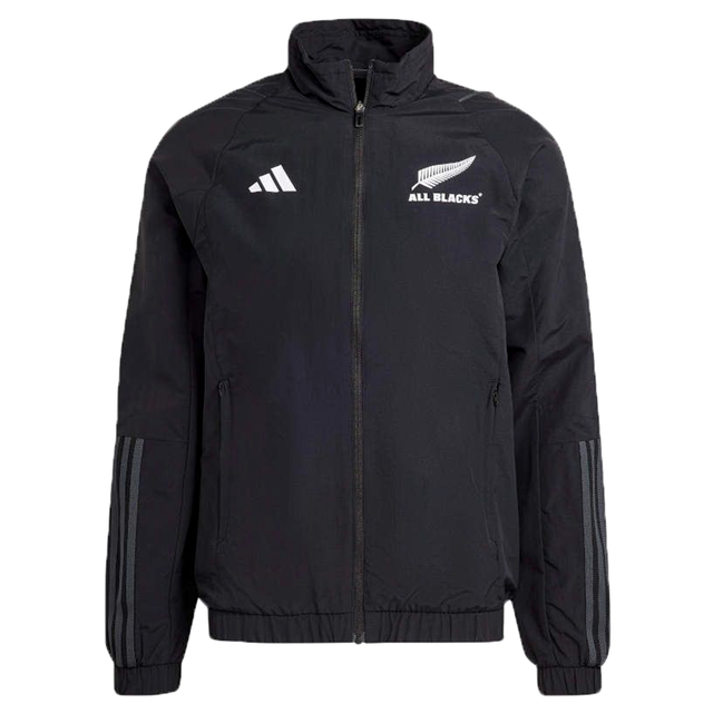 The All Blacks Presentation Jacket by adidas is a black sports jacket with the iconic "All Blacks" logo and signature adidas stripes on the sleeves and chest. Crafted from recycled nylon, it showcases a contemporary rugby style with a front zipper and high collar design.