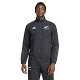Dressed in the All Blacks Presentation Jacket by adidas, a person showcases rugby fashion effortlessly with its sleek black design and white logos.