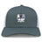 The Austin Huns Rugby Retro Trucker Cap by EMB S&S Activewear features gray and white panels, the Huns crest with a viking helmet, Texas symbol, rugby ball, "EST. 1972" embroidery on the front, and an adjustable snapback closure.