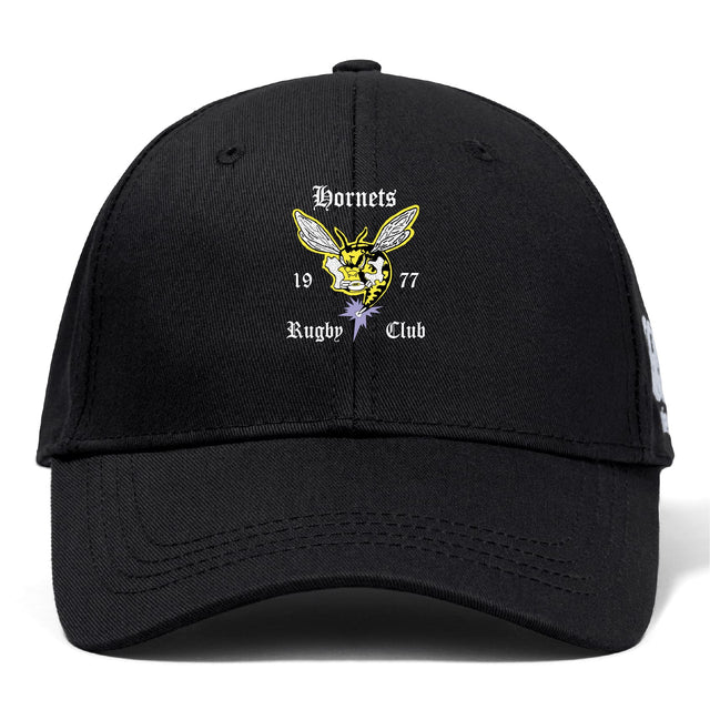 The Hornets Rugby Club Flexfit Drill Cap by EMB Canterbury features an embroidered hornet logo and "Hornets Rugby Club 1977" on the front, blending comfort with classic Canterbury style.