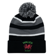 The EMB Augusta Nations of Rugby Wales Hooped Knit Fold Over Pom-Pom Beanie features black, grey, and white stripes, "WALES RUGBY" text, a pom-pom top, and an embroidered red dragon logo on the front.