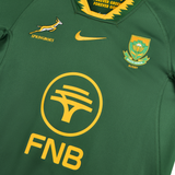 The Nike Springboks 26/27 Replica Home Jersey showcases the iconic Springboks logo, national crest, FNB branding, and Nike swoosh—a must-have green jersey for dedicated fans.