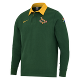 The Nike Springboks Home Long Sleeve Rugby Shirt features a green design with a yellow collar, South African flag patch on the sleeve, and Springbok chest logo—ideal for any South African rugby fan.