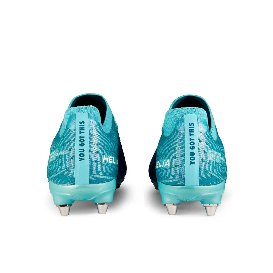 Rear view of two blue IDA Sports Ida Women's Helia Pro SG soccer cleats with "YOU GOT THIS" on the heel tab and "HELIA" on the side, featuring silver metal studs for lightweight performance on wet and muddy fields.