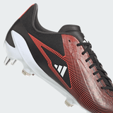 Close-up of the adidas Adizero RS15 Ultimate SG 24 soccer cleat in Core Black, Silver Metallic, and Solar Red. This cleat features a geometric pattern on the upper, black laces, white studs on the sole and is crafted from recycled materials by adidas.