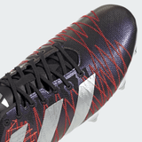 Close-up view of a black and red adidas Kakari Z.1 SG 24 rugby cleat in Core Black/Silver Metallic/Better Scarlet with silver stripes and black laces. The cleat features a textured pattern on the upper surface, incorporating recycled materials for an eco-friendly touch.