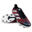 The adidas Kakari Z.1 SG 24 in Core Black, Silver Metallic, and Better Scarlet features a red and black patterned upper with white stripes on the sides. The cleats have white soles with durable metal studs. Crafted by adidas using recycled materials, one cleat is upright while the other lies on its side to highlight the robust sole design.