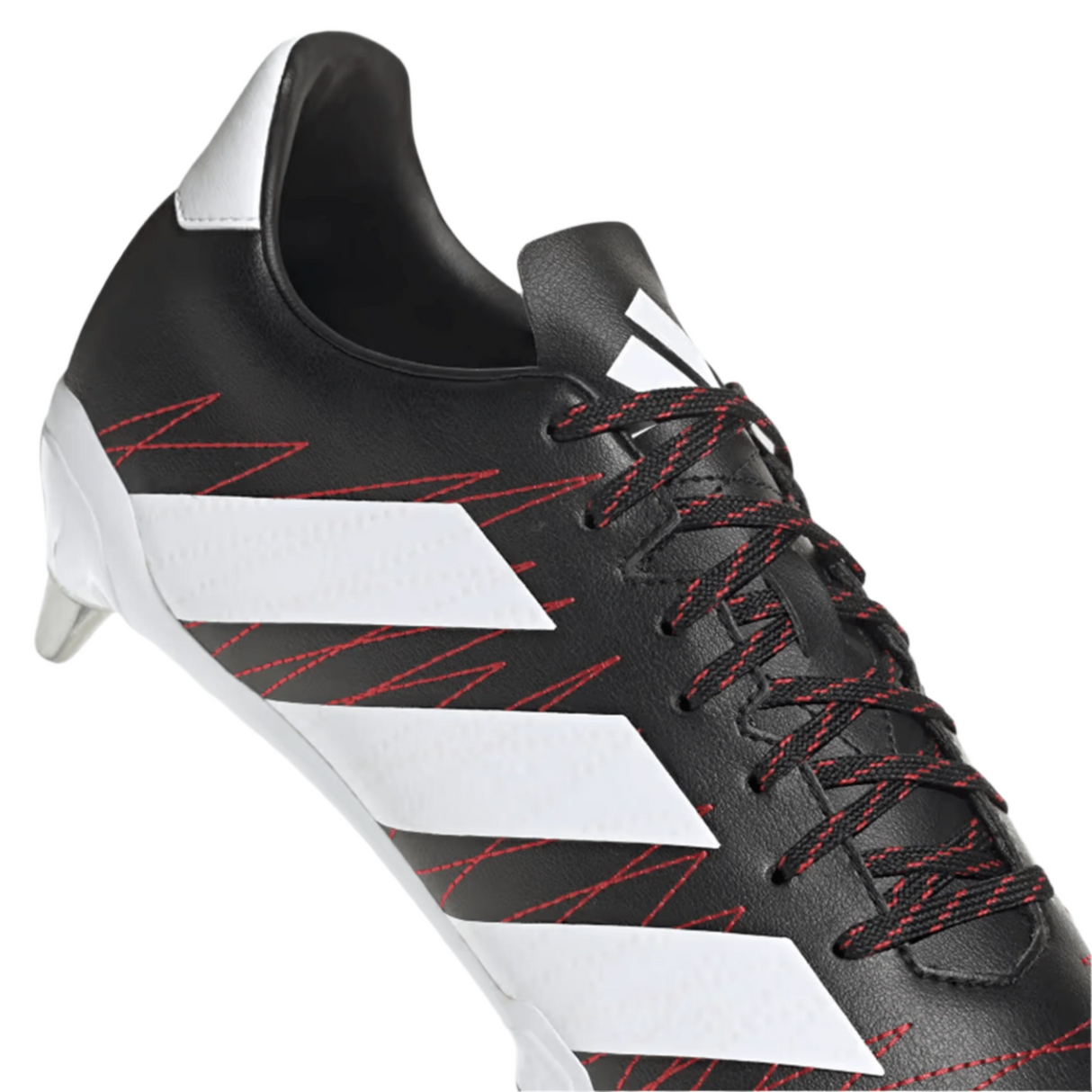 A close-up of the adidas Kakari SG rugby boot in Core Black, featuring white stripes and Better Scarlet stitching on the laces. The boot includes a metal stud on the heel and is crafted from recycled materials, designed for soft ground play.