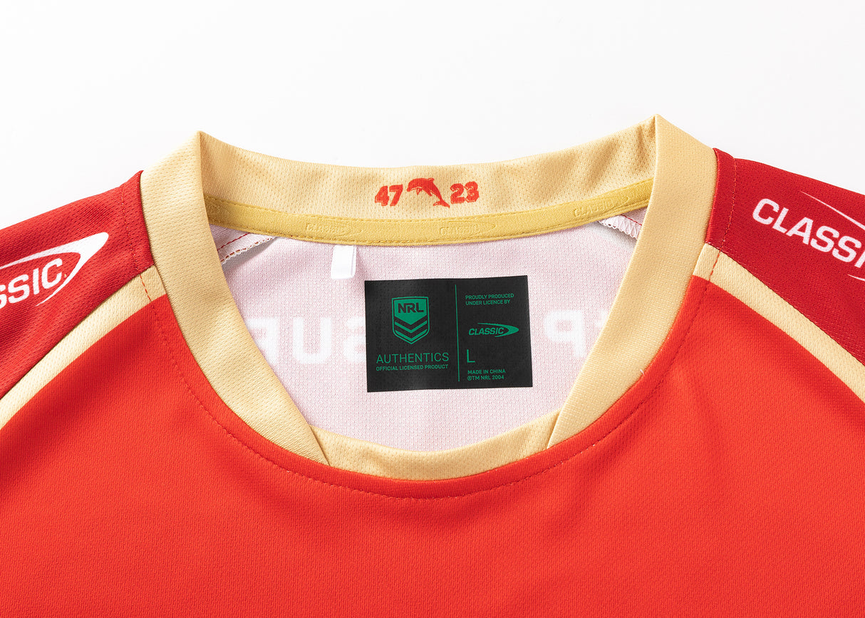 Close-up of a red and gold Dolphins NRL 25/26 Replica Home Jersey, showcasing a "47 23" collar design by Classic Sportswear, with an "NRL AUTHENTICS" label inside, size L.