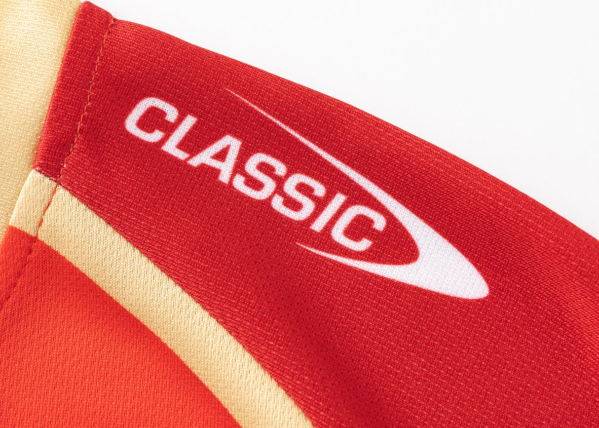 Close-up of a red and orange Dolphins NRL 25/26 Replica Home Jersey with "CLASSIC" and a swoosh logo on the sleeve, by Classic Sportswear.