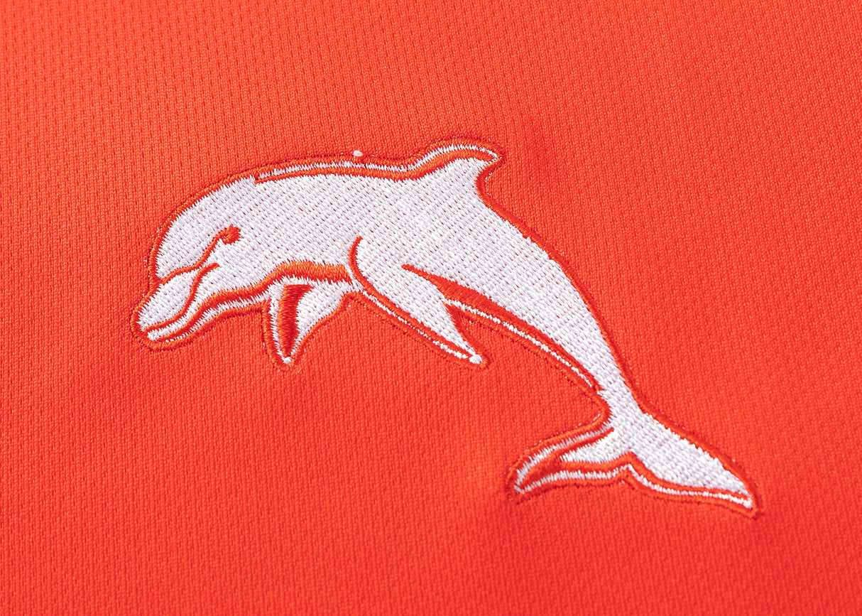 The Dolphins NRL 25/26 Replica Home Jersey by Classic Sportswear features white dolphin embroidery on orange fabric, embodying an iconic design.