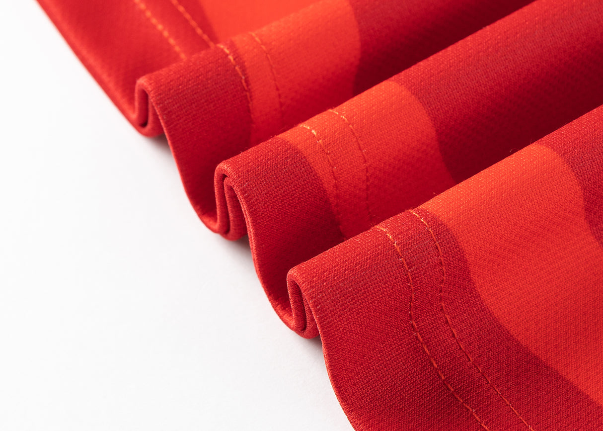 Detailed view of a red fabric with curved edges and visible stitching, echoing the superior craftsmanship of a Dolphins NRL 25/26 Replica Home Jersey by Classic Sportswear.