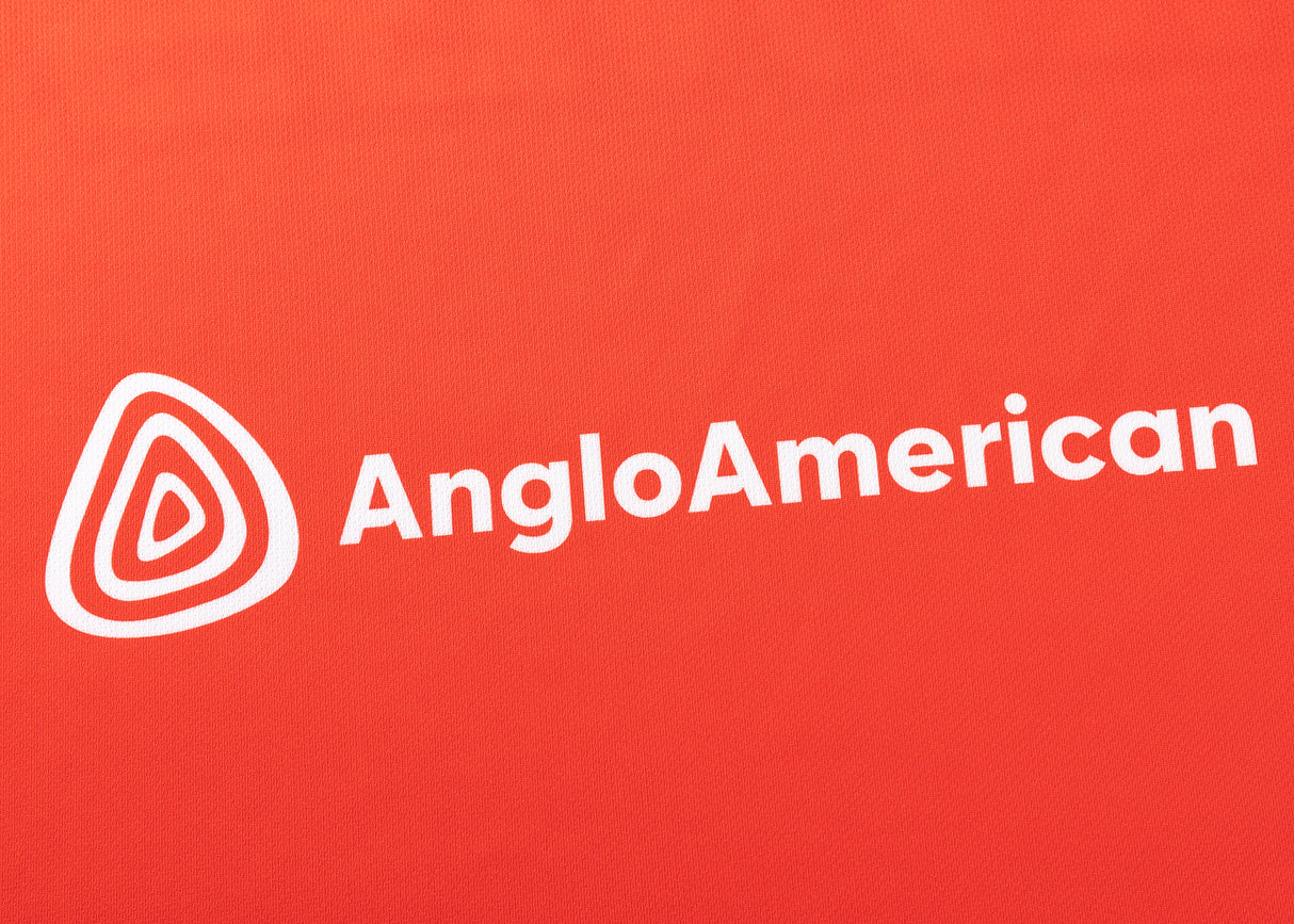 The image showcases the Anglo American logo in white on a red background, similar to the Dolphins NRL 25/26 Replica Home Jersey by Classic Sportswear.