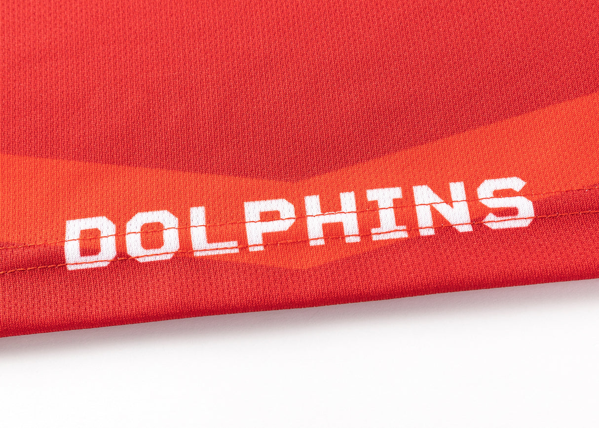 Classic Sportswear's Dolphins NRL 25/26 Replica Home Jersey features red fabric reminiscent of Classic design, with "DOLPHINS" in bold, white letters at the bottom edge. Perfect for fans wanting to show team pride.