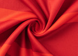Close-up of the Dolphins NRL 25/26 Replica Home Jersey by Classic Sportswear, featuring vibrant red fabric with swirling folds, textured surface, and various shades of red reminiscent of classic sportswear design.
