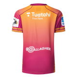 Back view of the Gallagher Chiefs Super Rugby Replica Training Jersey 25/26 by Classic Sportswear, with a gradient from orange to pink, featuring the "Tuataki First Fibre" and "Gallagher Chiefs" logos.