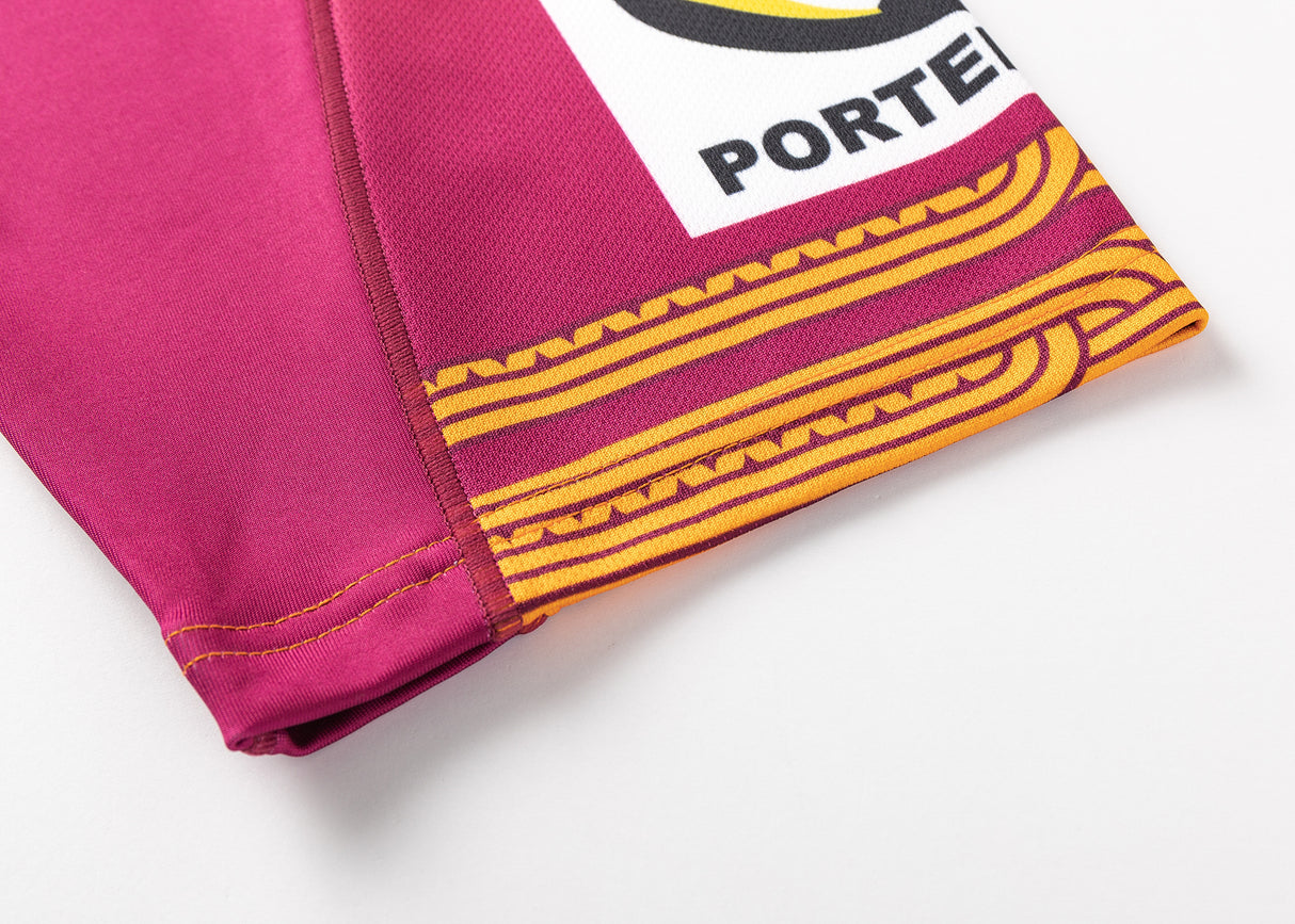 Close-up of maroon fabric with yellow patterns featuring a partial logo "PORTE," reminiscent of the Gallagher Chiefs Super Rugby Replica Training Jersey 25/26 by Classic Sportswear.