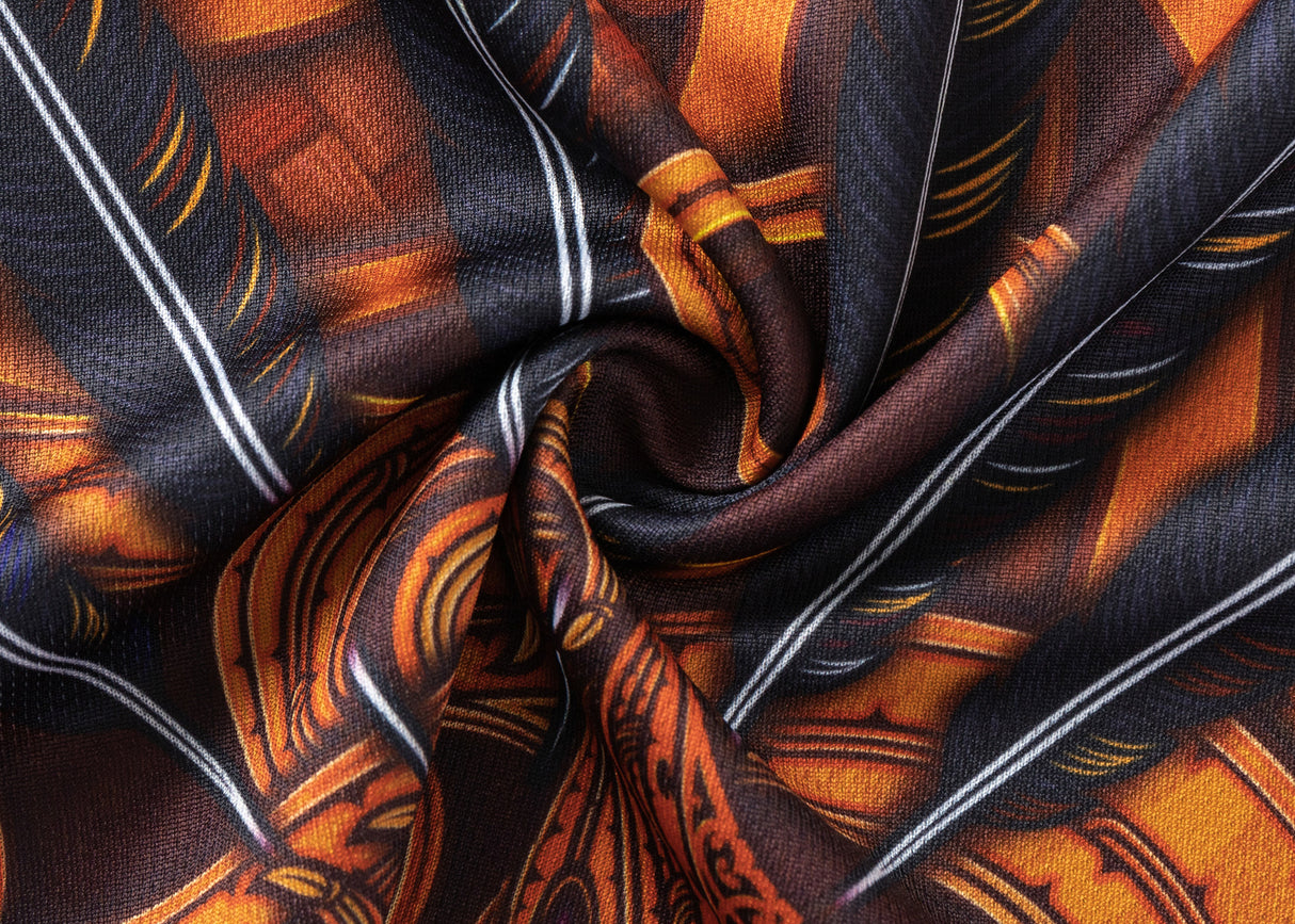 Close-up of the Gallagher Chiefs Super Rugby Replica Training Jersey 25/26 by Classic Sportswear, showcasing richly patterned fabric in orange and black with intricate geometric shapes and a classic sportswear aesthetic.