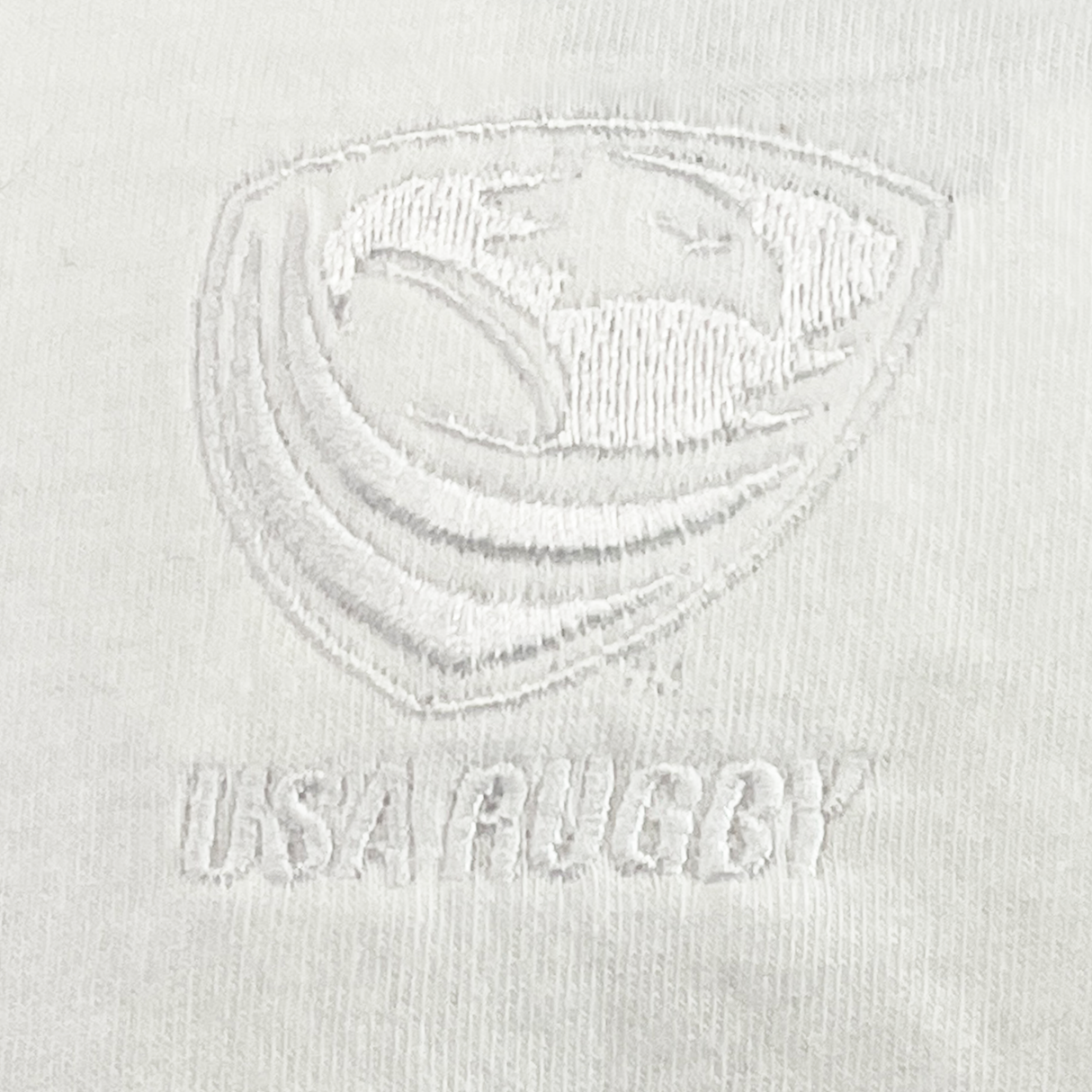 Close-up of the USA Rugby Elevated Tonal Comfort Tee by EMB Alpha Broder, crafted from ring-spun USA cotton and featuring an embroidered USA Rugby logo with a stylized eagle clutching a rugby ball above the text "USA RUGBY.