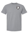 The Troy Rugby Comfort Tee by EMB S&S Activewear is a gray short-sleeve shirt crafted from ring-spun USA cotton, featuring a black and white shield emblem with letters and symbols on the upper left chest.