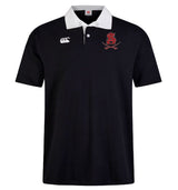 The Archbishop Spalding Solid Classic SS Rugby Jersey by EMB Canterbury is a black short-sleeved polo featuring a white collar, Canterbury branding on the right chest, and a red embroidered "SA" with crossed swords on the left.