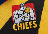 An embroidered patch featuring a muscular figure with a yellow object and "Gallagher Chiefs" on textured fabric adds nostalgic charm to Classic Sportswear's Limited Edition Gallagher Chiefs Super Rugby 25/26 Retro Jersey.