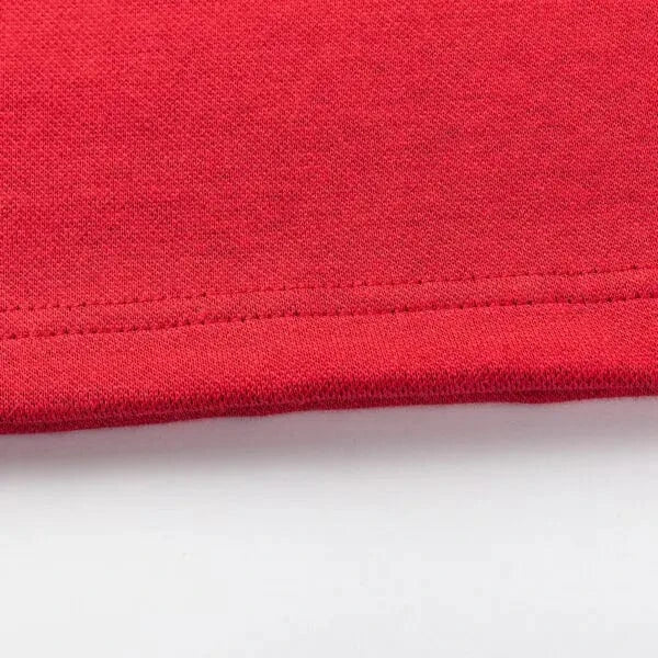 A close-up of a red fabric edge on a white background highlights detailed stitching characteristic of Classic Sportswear's Limited Edition Crusaders Super Rugby 25/26 Retro Jersey craftsmanship.