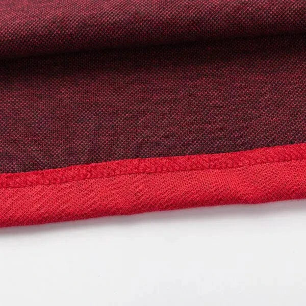 Close-up of a fabric with a red and black mesh pattern, similar to the Limited Edition Crusaders Super Rugby 25/26 Retro Jersey by Classic Sportswear, showcasing a vibrant red hem along the edge.