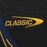 Close-up of the Limited Edition Hurricanes Super Rugby 25/26 Retro Jersey by Classic Sportswear logo, featuring "CLASSIC" in yellow embroidery with a curved line on dark fabric.