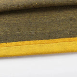Close-up of a textured fabric with a yellow edge, resembling the Limited Edition Hurricanes Super Rugby 25/26 Retro Jersey by Classic Sportswear. The darker shade features small dotted patterns, capturing classic sportswear's essence.