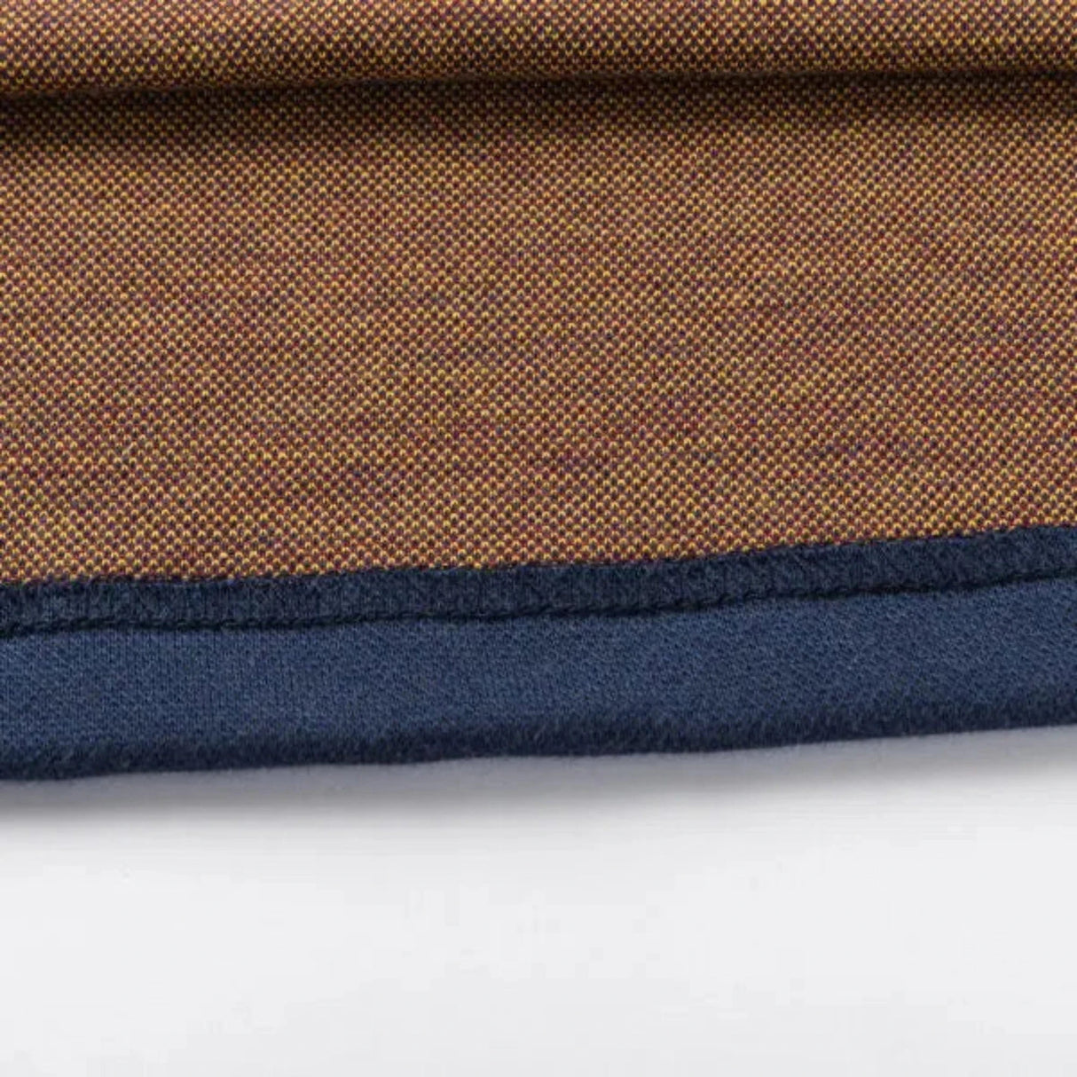 A close-up showcases the textured brown pattern and contrasting dark blue edge of the Limited Edition Highlanders Super Rugby 25/26 Retro Jersey by Classic Sportswear, reminiscent of classic sportswear, set against a white surface.