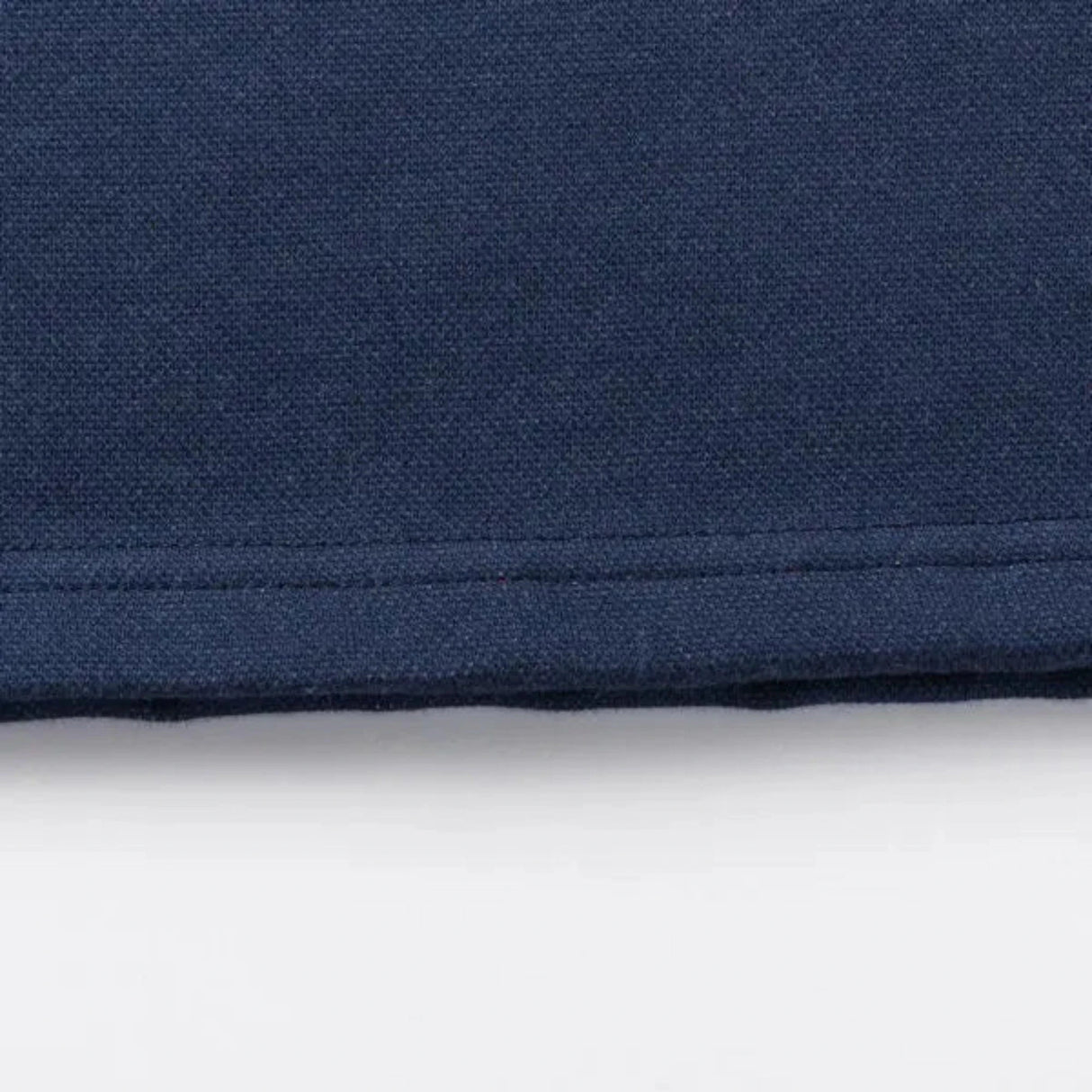 Close-up of a navy blue fabric from the Limited Edition Blues Super Rugby 25/26 Retro Jersey by Classic Sportswear, showcasing its classic sportswear design with visible edge stitching.