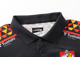 The Gallagher Chiefs Super Rugby 25/26 Team Polo by Classic Sportswear features colorful shoulder patterns with red, yellow, and black diamonds. Made from moisture-wicking fabric, it bears "Classic" and "Tuatahi First Fibre" labels, ideal for Chiefs fans seeking style and comfort.