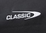 Close-up of "CLASSIC" embroidered in white with a curved underline on black, moisture-wicking fabric by Classic Sportswear—a feature of the Gallagher Chiefs Super Rugby 25/26 Team Polo.