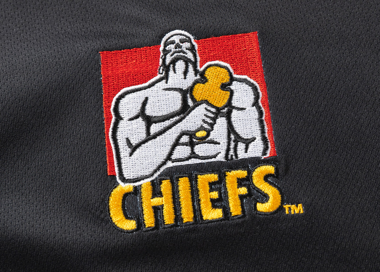 The Gallagher Chiefs Super Rugby 25/26 Team Polo by Classic Sportswear showcases a muscular figure with a hammer on a red background, while "CHIEFS" features in yellow on moisture-wicking fabric, capturing the dynamic spirit of Chiefs Super Rugby.