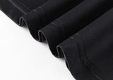 Close-up of the hem of a moisture-wicking black fabric from the Gallagher Chiefs Super Rugby 25/26 Team Polo by Classic Sportswear, showing four neatly folded edges on a white background.