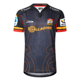 The Classic Sportswear Gallagher Chiefs Super Rugby Replica Home Jersey 25/26 features a dark intricate pattern, with the "Gallagher" text, Chiefs logo, and sponsor logos on the sleeves. Ideal for any Super Rugby fan eager to support the team proudly.