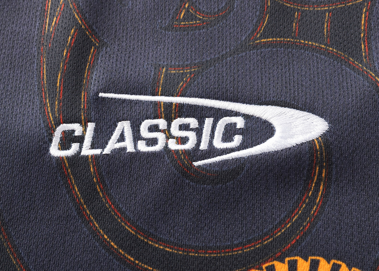 Zoom in on the word "CLASSIC" embroidered in white on dark fabric, echoing the bold orange stitching of the Gallagher Chiefs Super Rugby Replica Home Jersey 25/26 by Classic Sportswear.