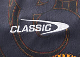 Zoom in on the word "CLASSIC" embroidered in white on dark fabric, echoing the bold orange stitching of the Gallagher Chiefs Super Rugby Replica Home Jersey 25/26 by Classic Sportswear.