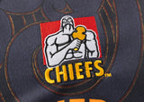 Fabric adorned with a muscular figure holding a hammer and "CHIEFS" in bold yellow letters, this Gallagher Chiefs Super Rugby Replica Home Jersey 25/26 by Classic Sportswear embodies team spirit and pride.