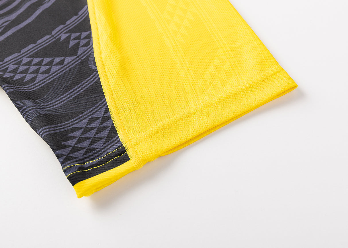 Close-up of a fabric corner showcasing a black and yellow geometric pattern on a light surface, similar to the Hurricanes Super Rugby 25/26 Replica Home Jersey by Classic Sportswear.