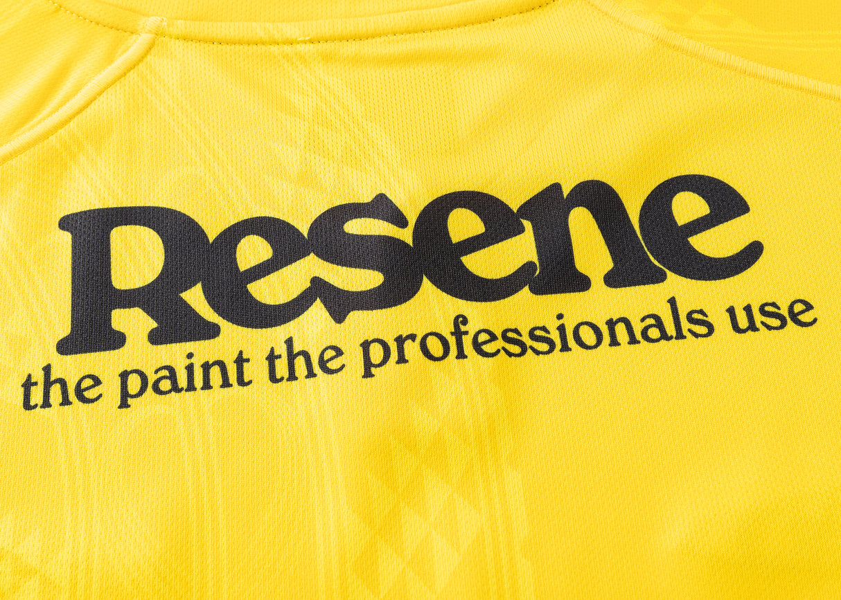 Yellow fabric with a bold black "Resene" logo and smaller text reading "the paint the professionals use," designed like a Hurricanes Super Rugby 25/26 Replica Home Jersey by Classic Sportswear.