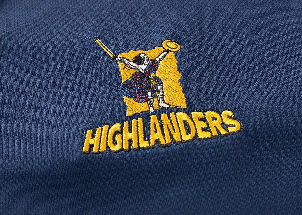 The Highlanders Super Rugby 25/26 Replica Home Jersey by Classic Sportswear features a blue, moisture-wicking fabric with an embroidered Highlander logo wielding a sword and shield above "HIGHLANDERS," celebrating the team's spirit and perfect for fans.