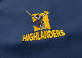 The Highlanders Super Rugby 25/26 Replica Home Jersey by Classic Sportswear features a blue, moisture-wicking fabric with an embroidered Highlander logo wielding a sword and shield above "HIGHLANDERS," celebrating the team's spirit and perfect for fans.