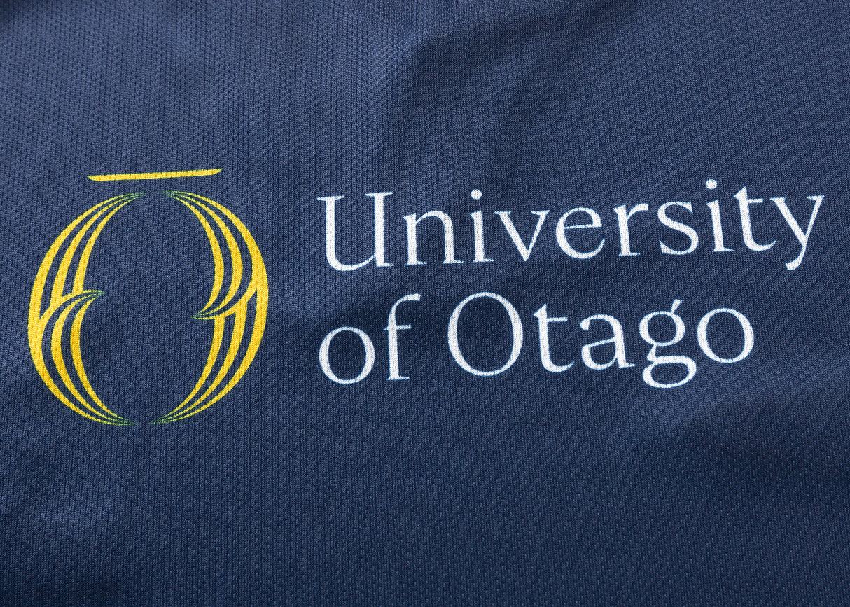The Highlanders Super Rugby 25/26 Replica Home Jersey by Classic Sportswear features "University of Otago" text and a stylized yellow logo on a dark blue, moisture-wicking fabric.