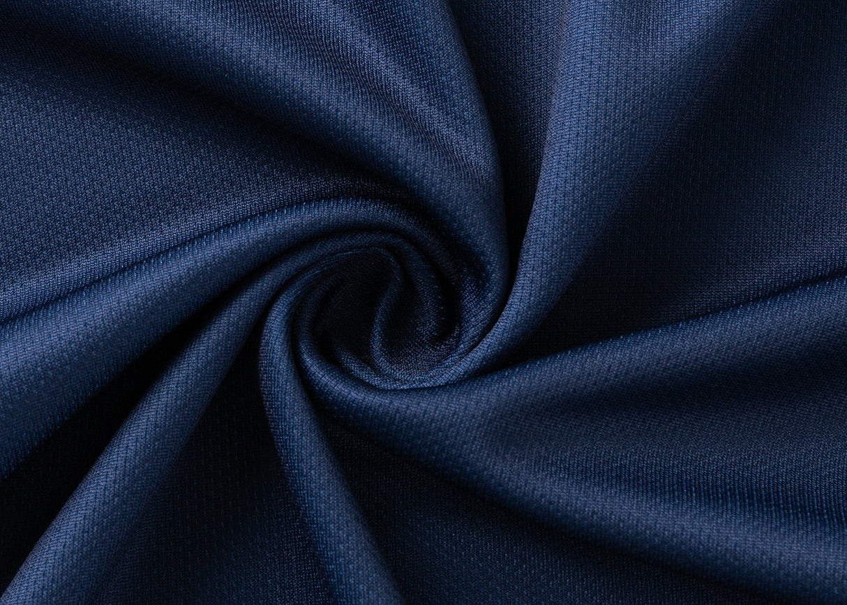 A close-up of dark blue, textured fabric, twisted at the center to form a spiral pattern, resembles the moisture-wicking Highlanders Super Rugby 25/26 Replica Home Jersey by Classic Sportswear.