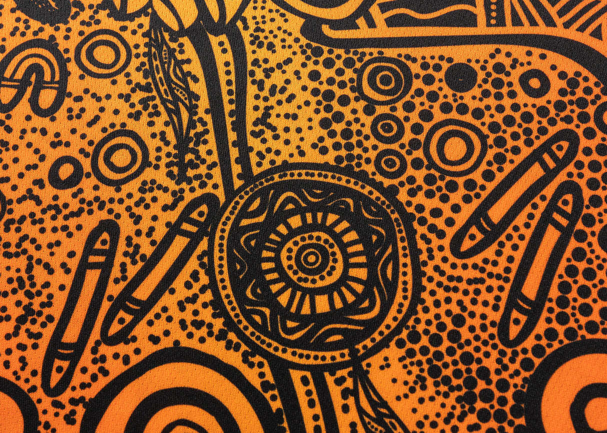 The NRL Indigenous All Stars 25/26 Pro Training Singlet by Classic Sportswear features an abstract design with concentric circles and dotted patterns in black on an orange background.