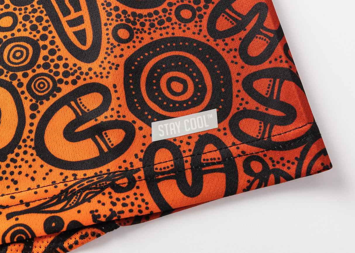 Close-up of an orange and black fabric with abstract patterns, resembling the NRL Indigenous All Stars 25/26 Pro Training Singlet by Classic Sportswear, showcasing a small tag reading "STAY COOL™.