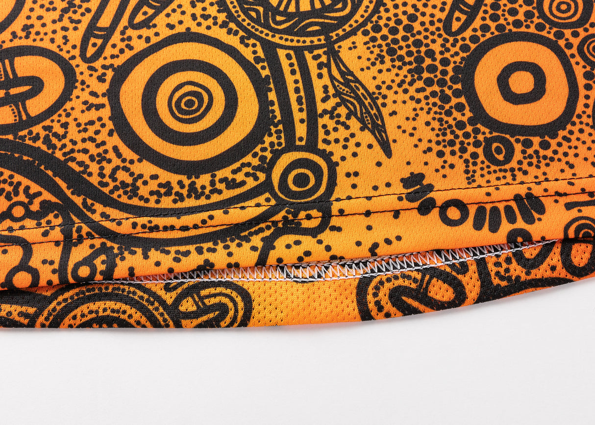 Close-up of an orange fabric with black abstract circular and dotted patterns, resembling the dynamic designs on the NRL Indigenous All Stars 25/26 Pro Training Singlet by Classic Sportswear.